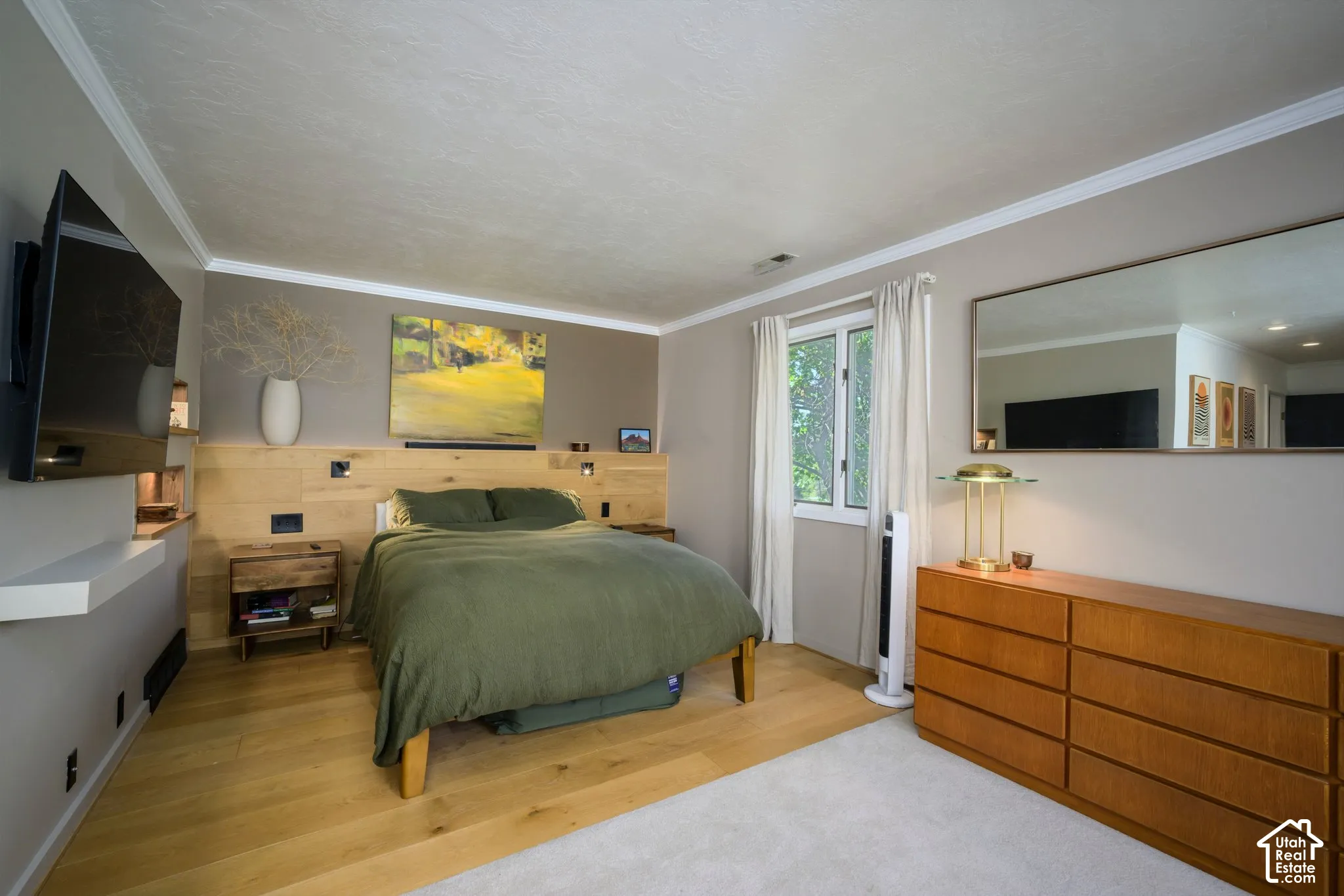 Wood-finish flooring, accent wall with wood paneling, built-in shelving, white trim, and a window with natural light