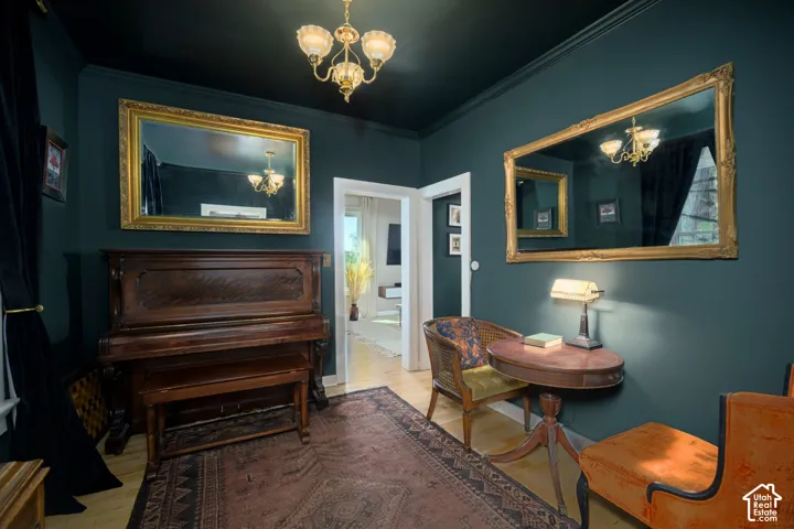 Dark-toned walls with contrasting white trim, hardwood flooring, and a brass chandelier
