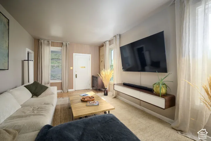 Wood-finish flooring, wall-mounted display, and a built-in floating media console