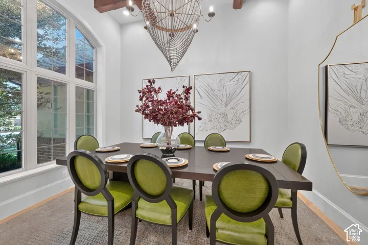 Arched window with multiple panes, exposed ceiling beam, and a decorative chandelier