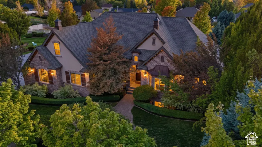 Elegant stone and brick exterior with multiple gabled rooflines and slate-colored asphalt shingles