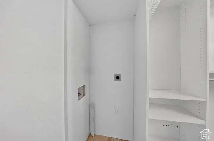 Laundry area with utility hookups and adjacent built-in shelving