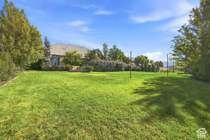 Expansive green lawn with mature trees and a distant mountain backdrop