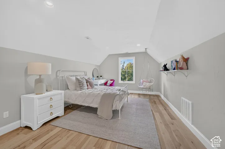 Sloped ceilings, recessed lighting, wood-finish flooring, and window