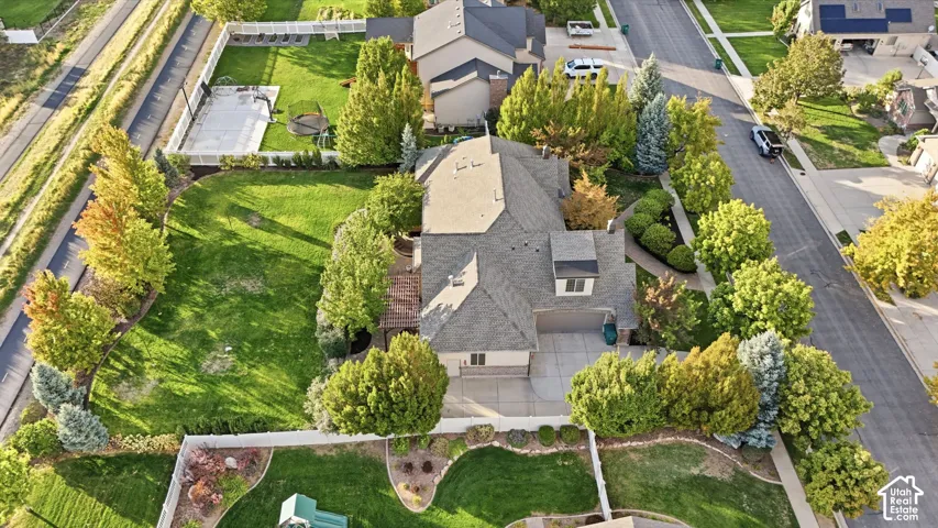 Expansive residential property with a multi-level roofline, attached garage, and surrounding mature landscaping