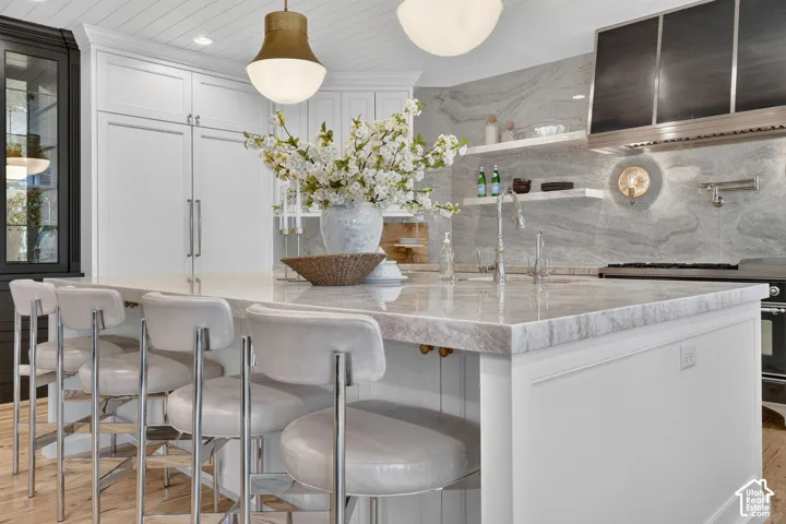 Spacious kitchen island with a thick stone countertop, paneled base, and integrated seating