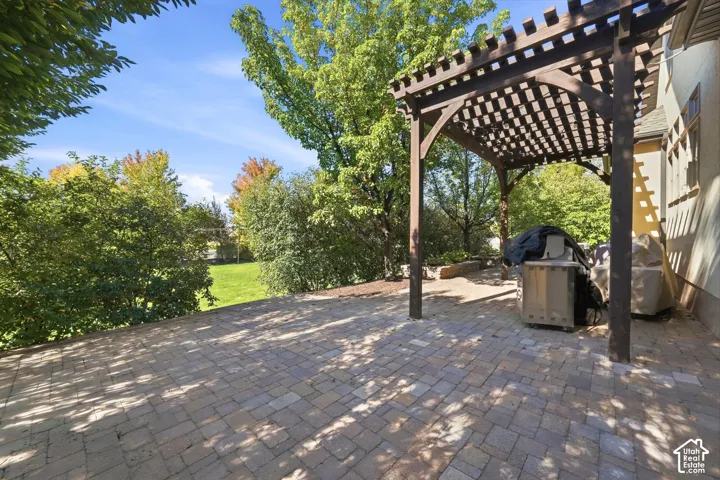 Expansive paver patio with a wooden pergola