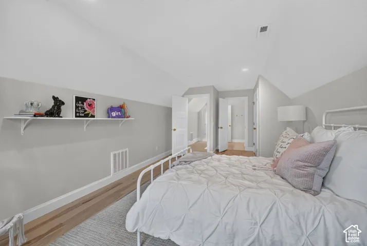Recessed lighting with a white ceiling, light wood-finish flooring, and a built-in wall shelf