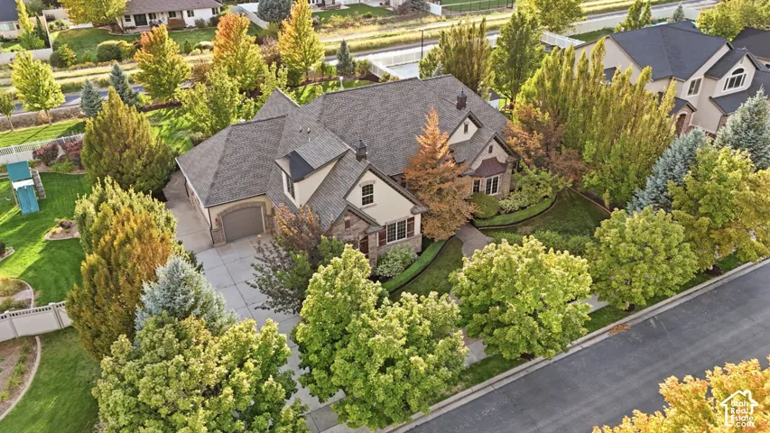 Two-story residence with a gray shingle roof, stone and stucco exterior, and an attached two-car garage