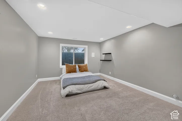 Recessed ceiling lighting, window with white trim, carpeting, floating wall shelves, and white baseboards