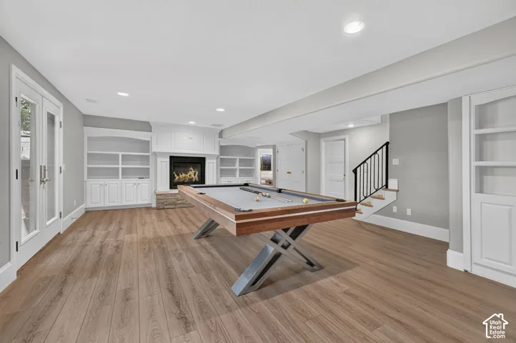 Wood-finish flooring throughout, with recessed lighting and built-in shelving