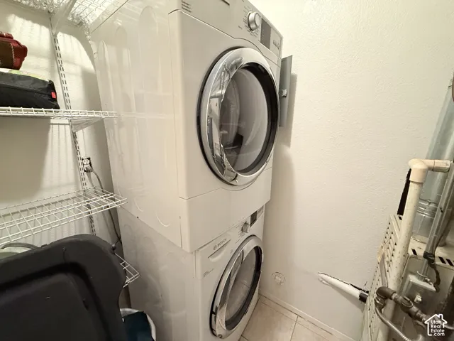 Stackable laundry appliances with front-load design, wire shelving system, and tiled flooring