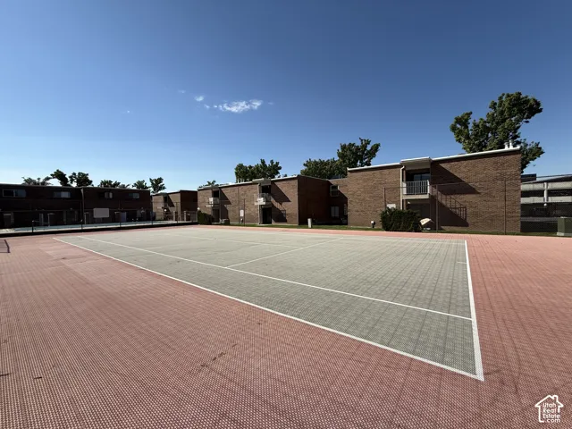 Hard surface tennis court with red and grey playing areas