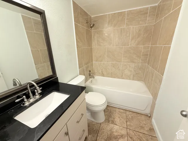 Bathroom featuring a white vanity with a black countertop, undermount sink, and brushed nickel faucet