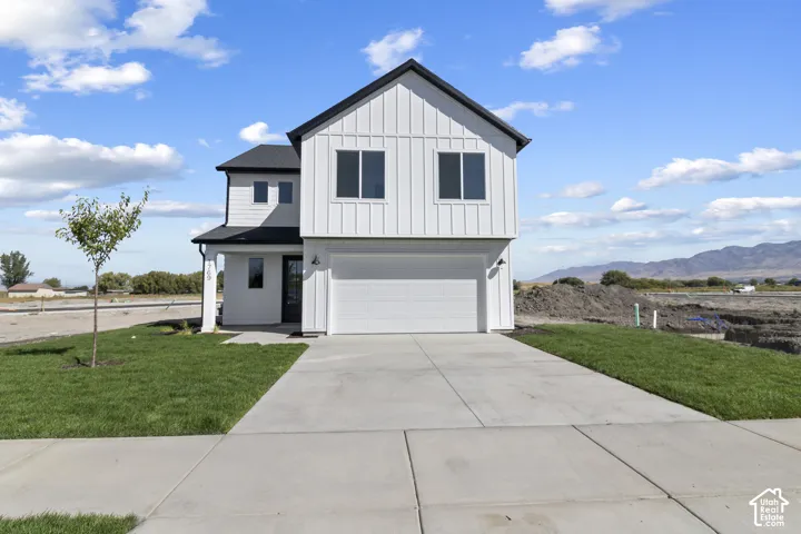 Contemporary exterior with white vertical siding, black trim windows, a two-car garage, and a concrete driveway