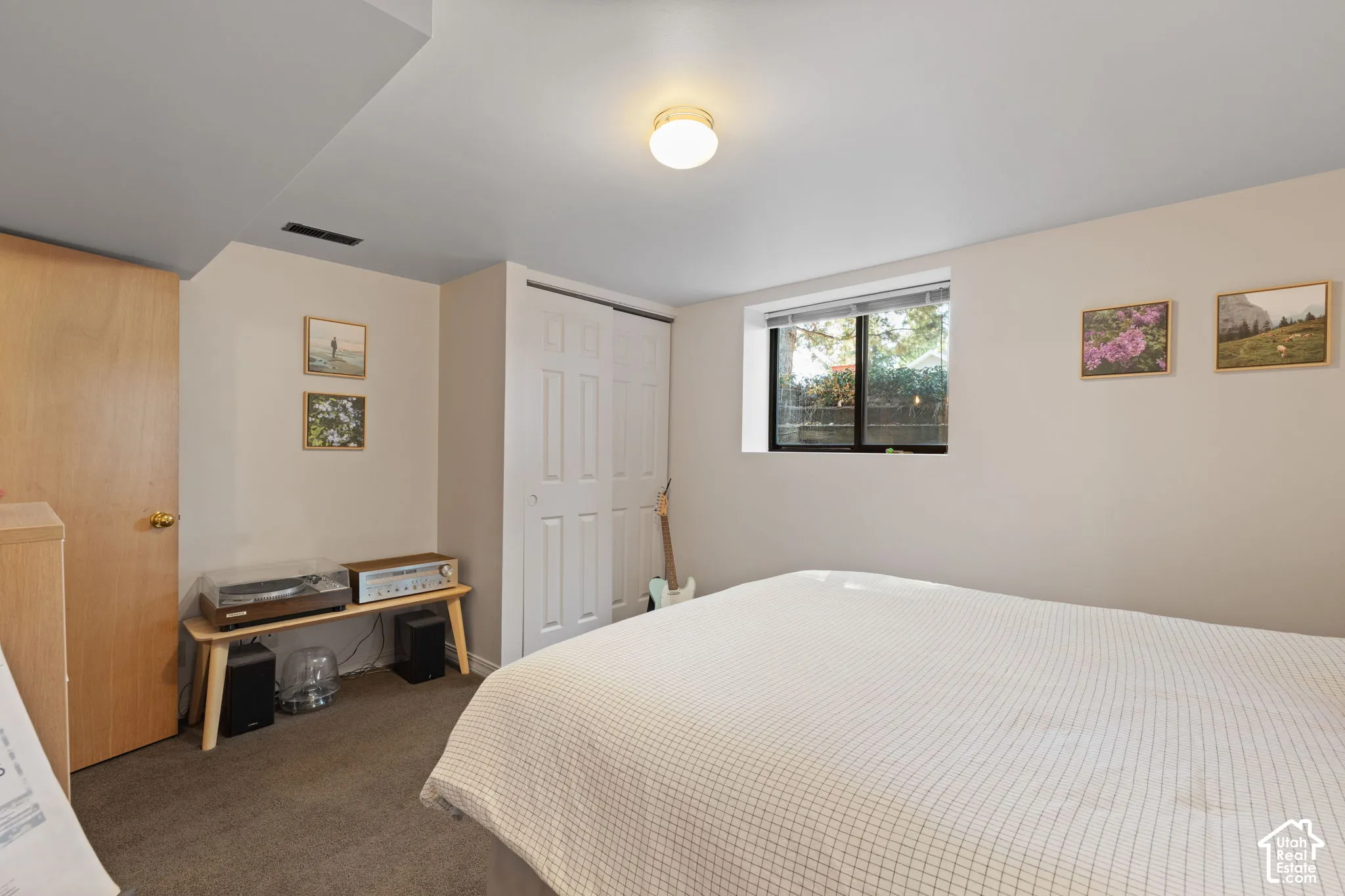 Carpeted flooring, egress window, white bi-fold closet doors, and wood-finish interior door