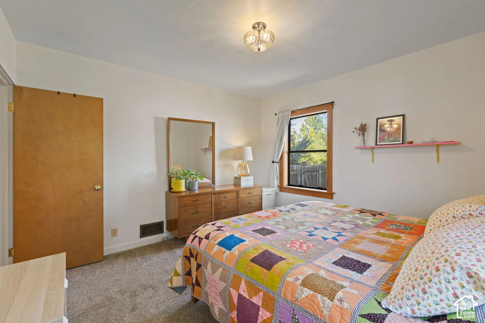 Recessed window with wood trim, wall-mounted shelving, and overhead lighting