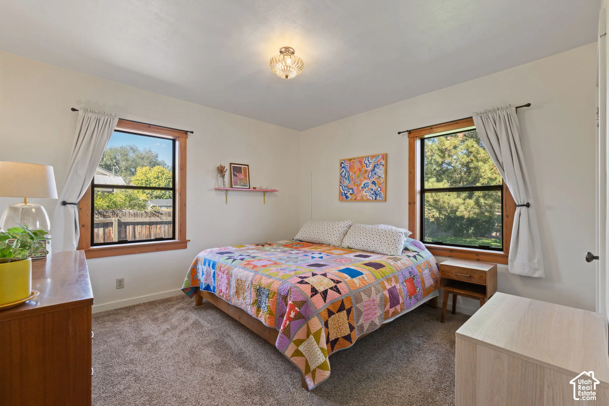 Recessed lighting fixture, light-colored walls, carpeted flooring, and two windows with wood-finish trim