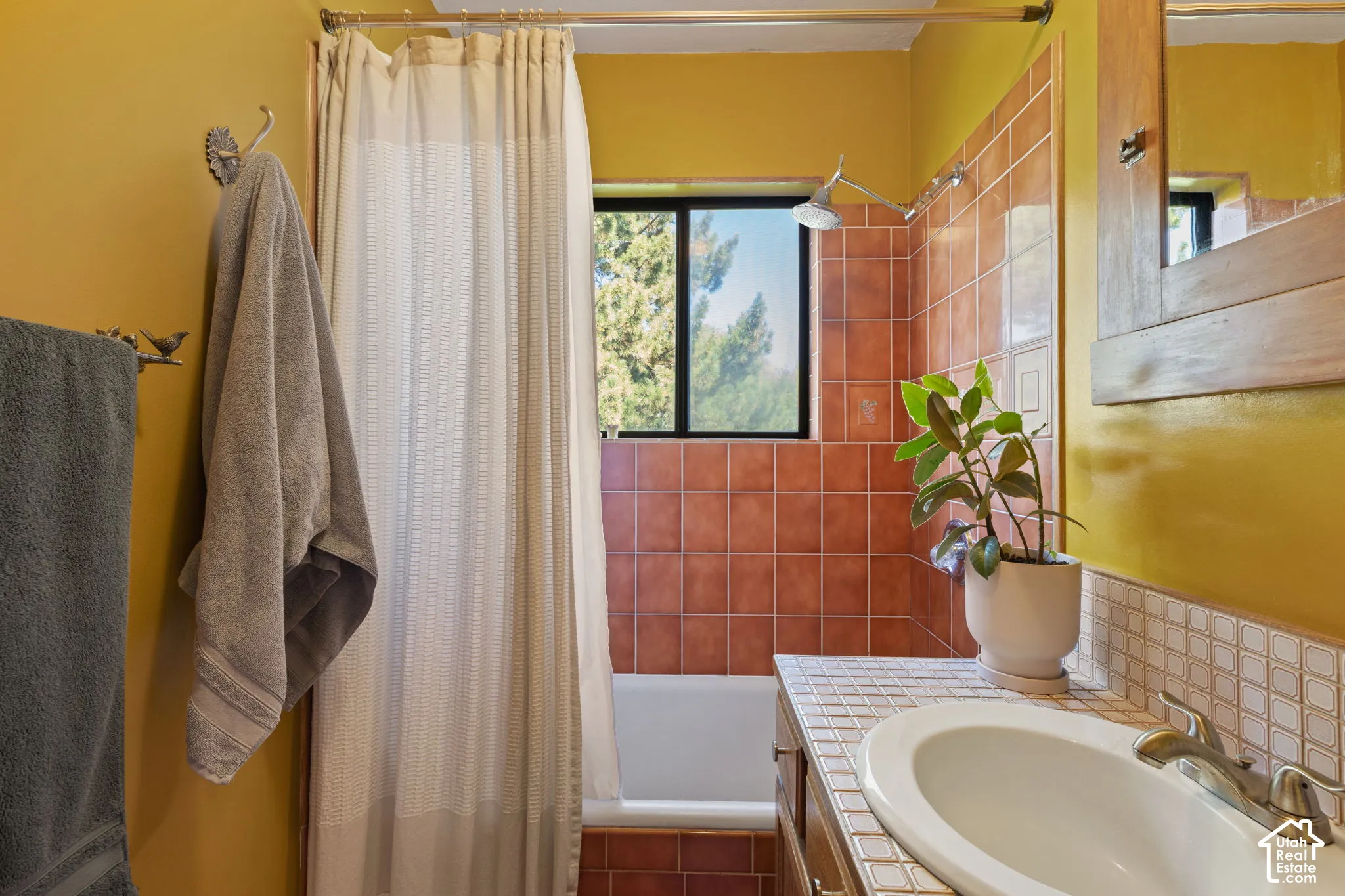 Built-in bathtub with subway tile surround, integrated showerhead, and a vanity with a drop-in sink