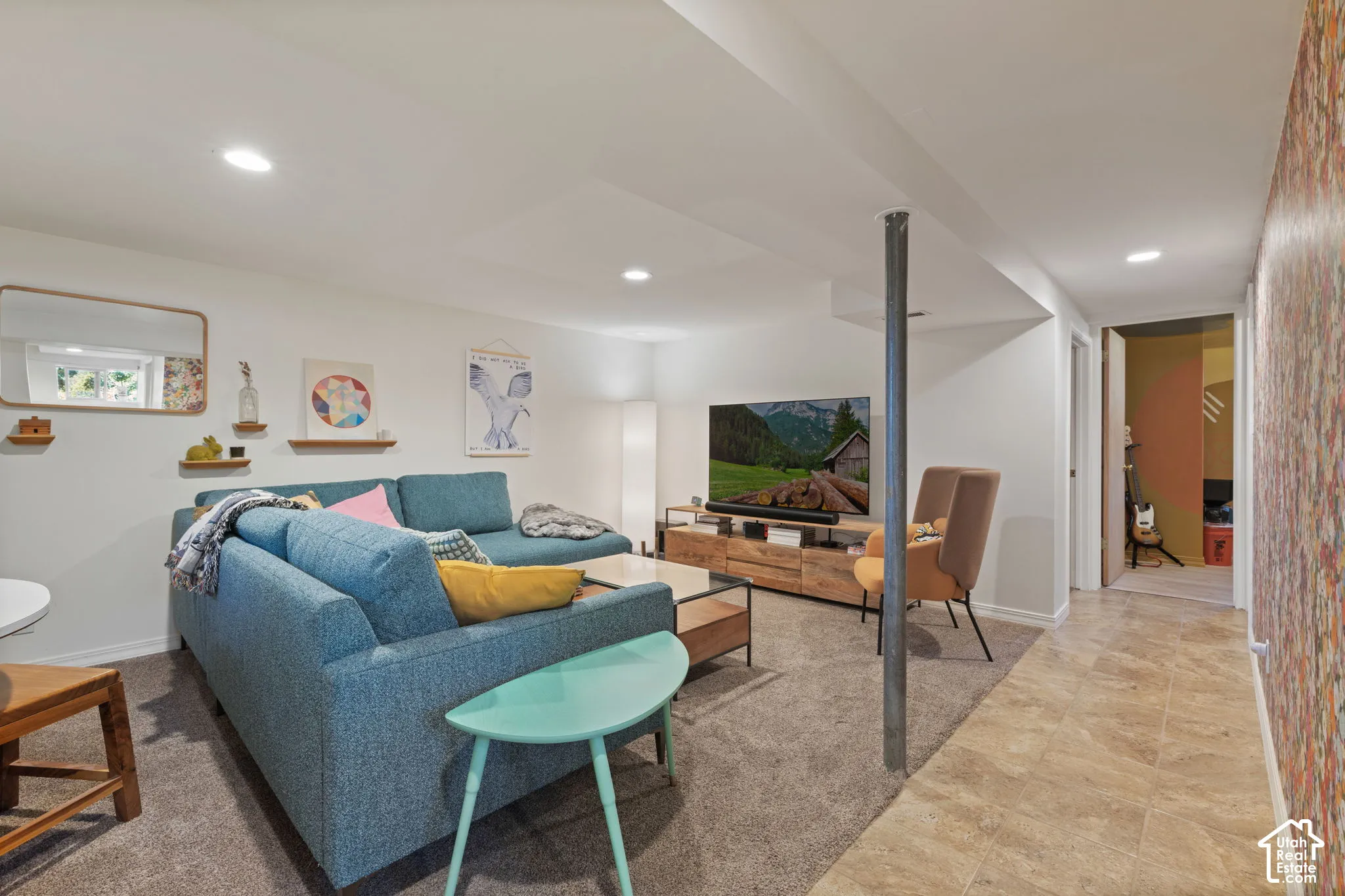 Recessed lighting, wood-finish media console, neutral wall color, tiled flooring, and carpeted area