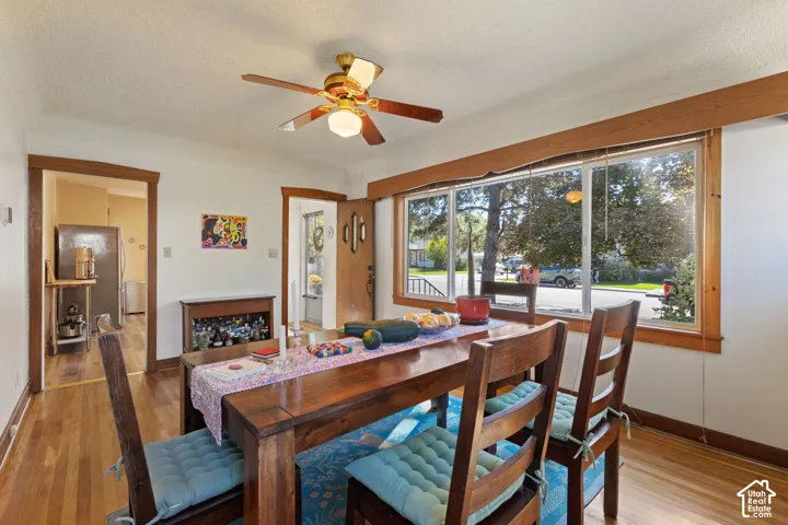 Hardwood flooring, painted walls, ceiling fan with integrated lighting, wood-trimmed windows, and wood door frames