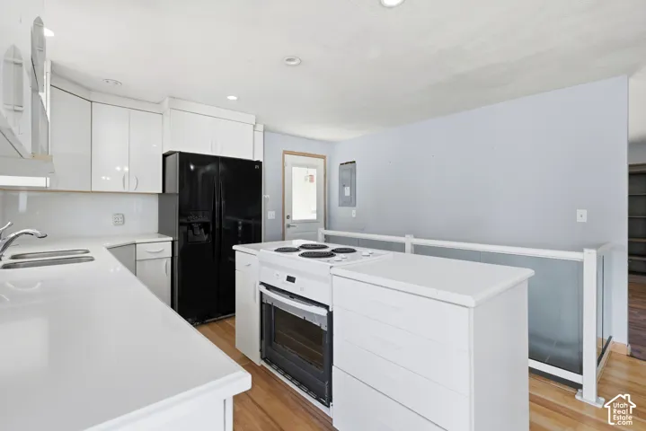 White cabinetry, white countertop surfaces, and wood-finish flooring