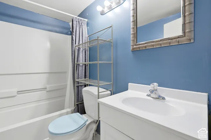 White vanity with integrated sink, chrome faucet, and a wall-mounted mirror with a textured frame