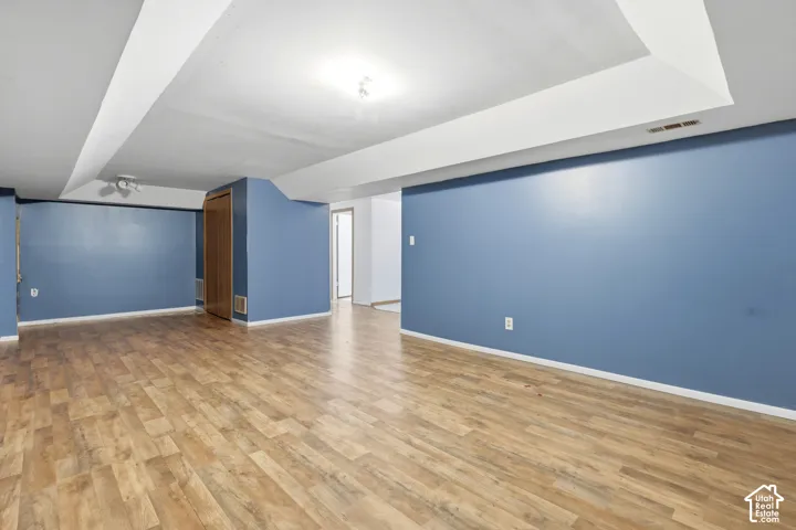 Expansive room with wood-finish flooring, recessed lighting, and painted walls