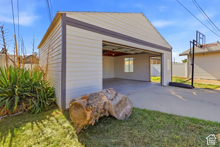 Detached garage with horizontal siding, a concrete driveway, and an interior window