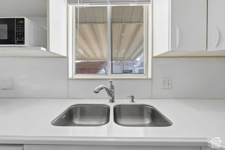 White countertops with an integrated double basin stainless steel sink