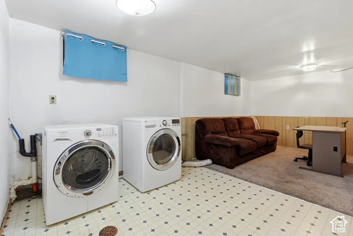 Laundry area with washer and dryer, patterned vinyl flooring, and paneled wall sections