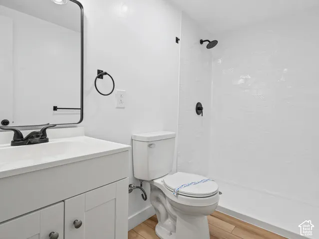 White vanity with a rectangular sink, matte black faucet, and modern framed mirror