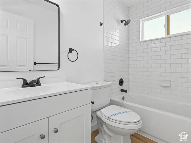 White subway tile shower surround with a window, complete with a dark-finished shower head and tub filler