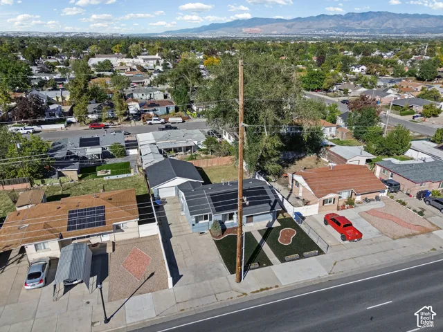 Single-story residence featuring a gray exterior and a dark roof with solar panels