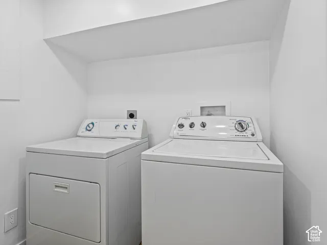 Dedicated laundry area with built-in shelving, equipped with a washer and dryer