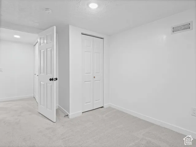 Light gray carpeting, white trim, recessed lighting, and white paneled doors