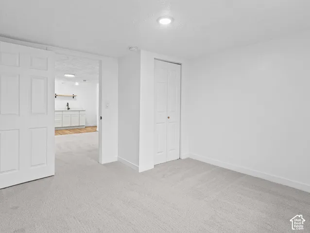 Plush carpet flooring, white walls, white bi-fold closet door, recessed lighting