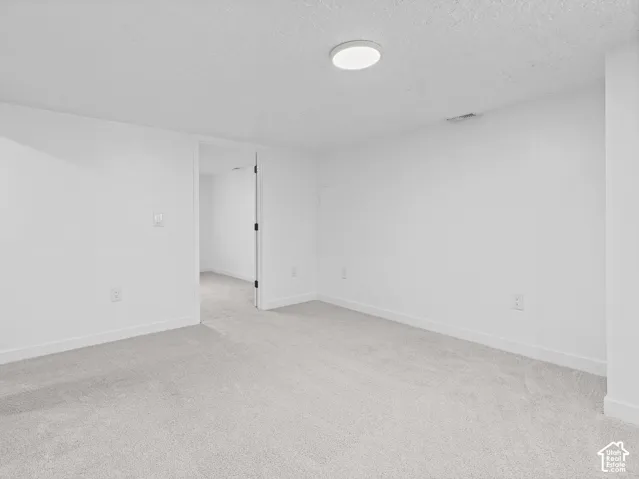 Light-toned carpeting, white walls, and a contemporary flush-mount ceiling light fixture