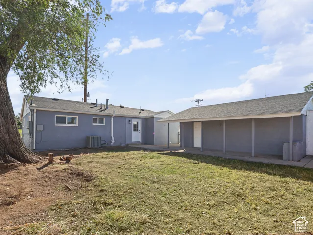 Rear exterior with blue siding, white trim, and a white entry door