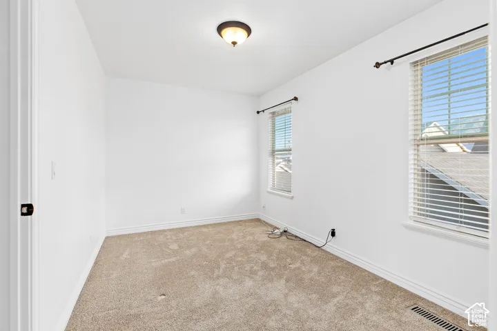 White walls with two pane windows and light brown carpeting