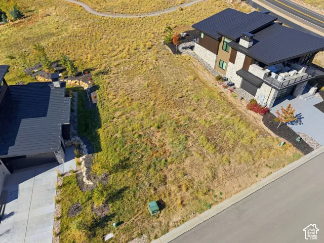 Expansive undeveloped lot with sloping terrain, featuring direct street access