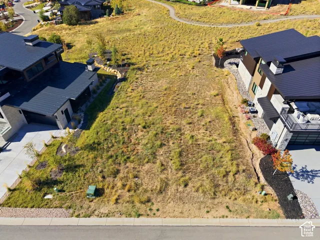 Expansive lot with a gravel and concrete border, featuring a sloped terrain
