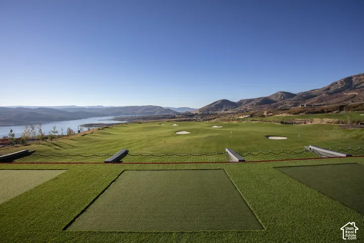 Expansive golf course featuring multiple sand traps, artificial turf hitting bays, and a protective netting system