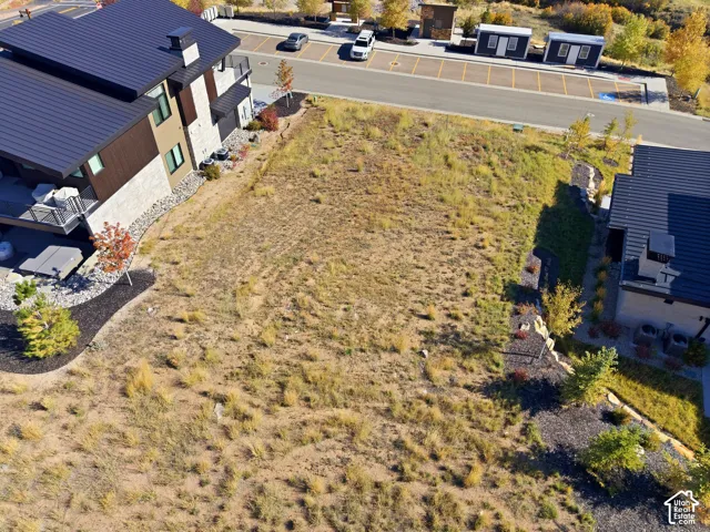 Expansive undeveloped lot with partial landscaping, including small trees and gravel