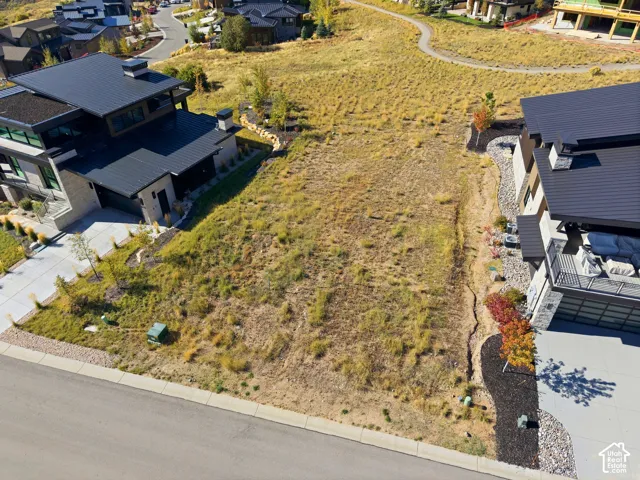 Expansive vacant lot featuring natural ground cover, a paved street frontage, and established utility boxes