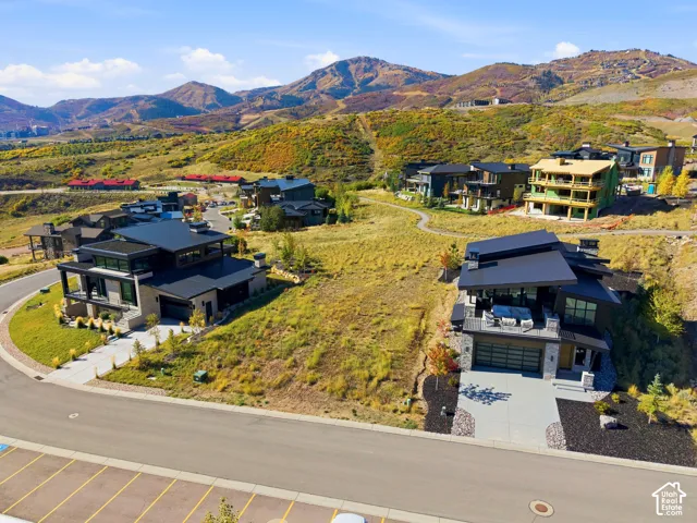 Modern architectural design with a flat roofline, multi-level construction, integrated garage, and a spacious outdoor deck