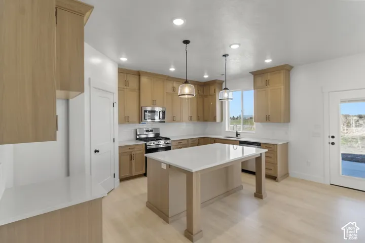 Kitchen featuring wood-finish cabinetry, white countertops, a subway tile backsplash, and stainless steel appliances