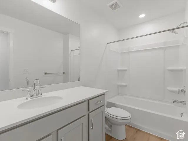 Full vanity mirror, undermount sink, chrome faucet, white countertop, and wood-finish flooring