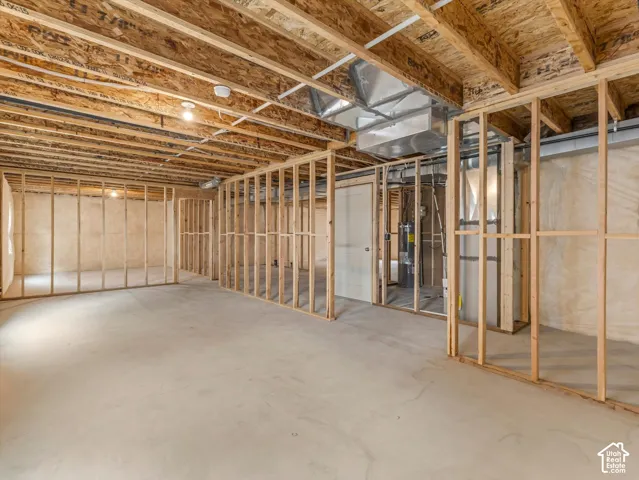 Unfinished basement featuring wood framing, concrete flooring, exposed ceiling joists, and visible ductwork