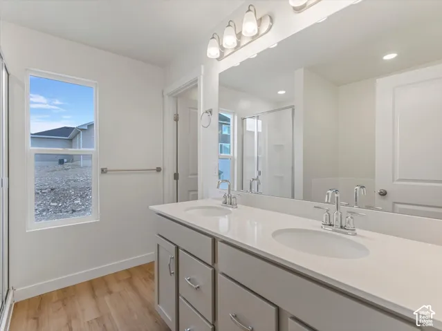 Dual vanity featuring undermount sinks, chrome fixtures, and light-toned cabinetry